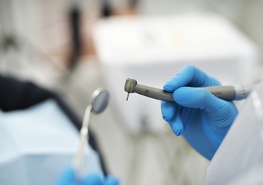 close up photo of a dentist holding instruments