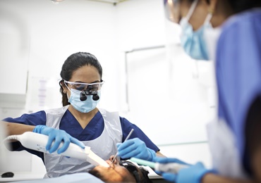 Dentist treating a patient on a chair in a dental practice