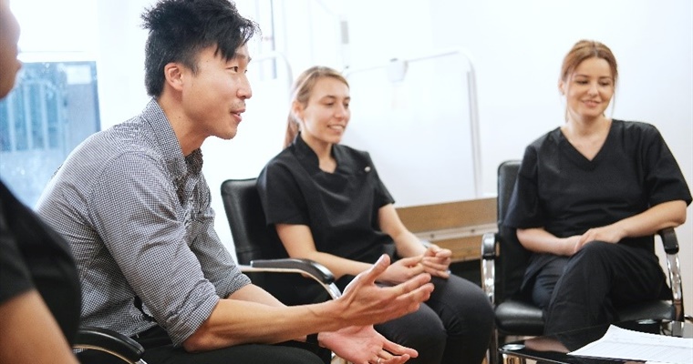 A man and two women sat in a group, mid-discussion.