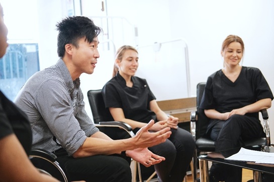 A man and two women sat in a group, mid-discussion.