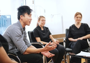 A man and two women sat in a group, mid-discussion.