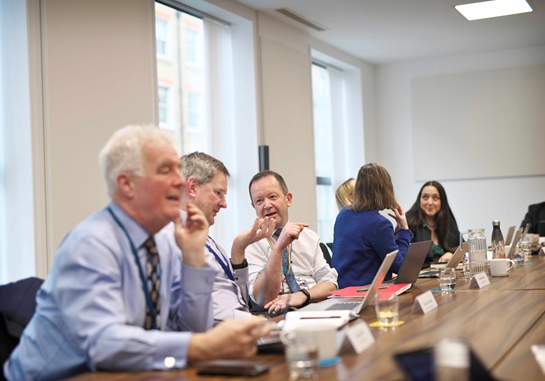 Image of people sitting around a table and talking