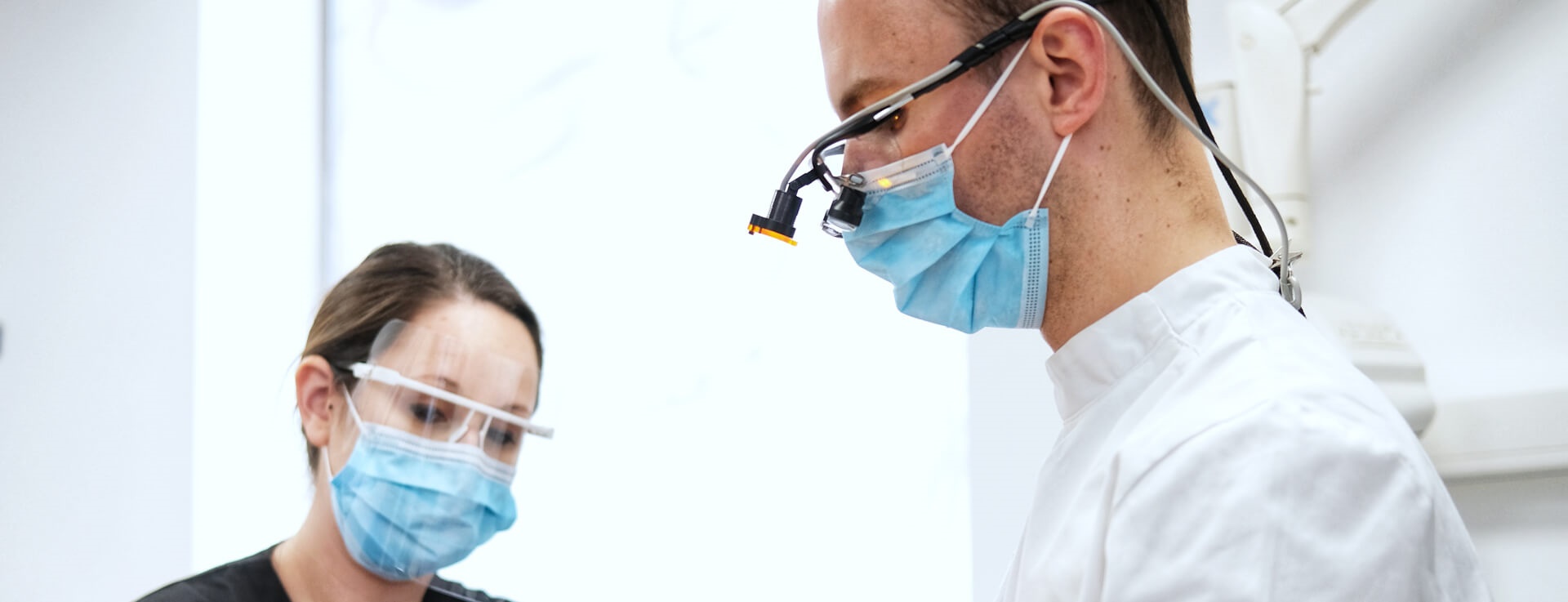 two dental professionals treating patient