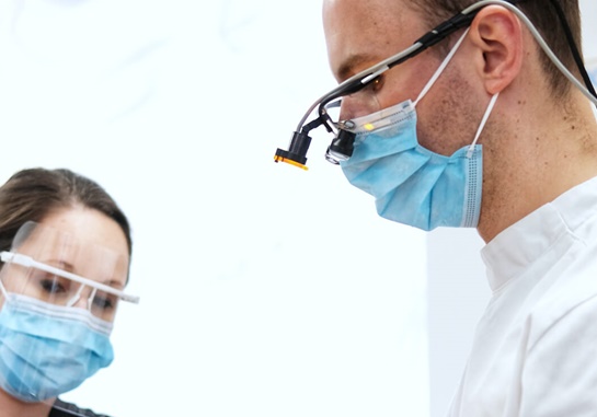 two dental professionals treating patient