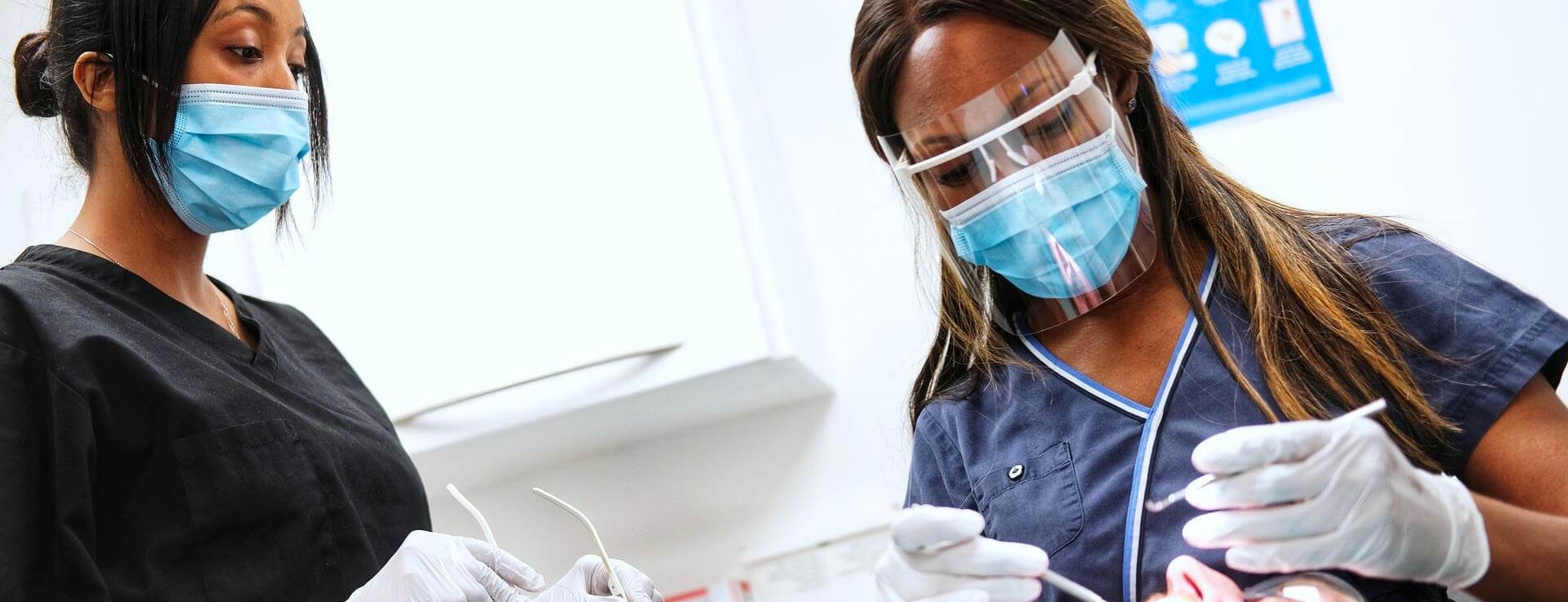 Two dentists treating patient